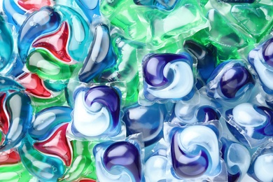 Photo of Many different laundry capsules as background, top view