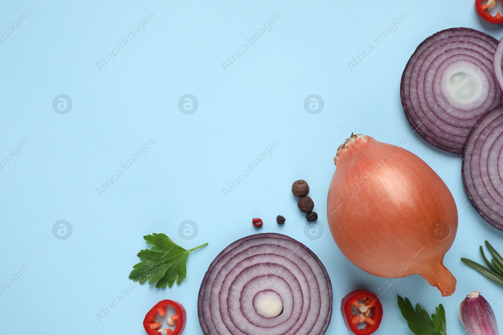 Photo of Flat lay composition with onion and spices on light blue background. Space for text