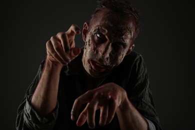 Scary zombie on dark background. Halloween monster