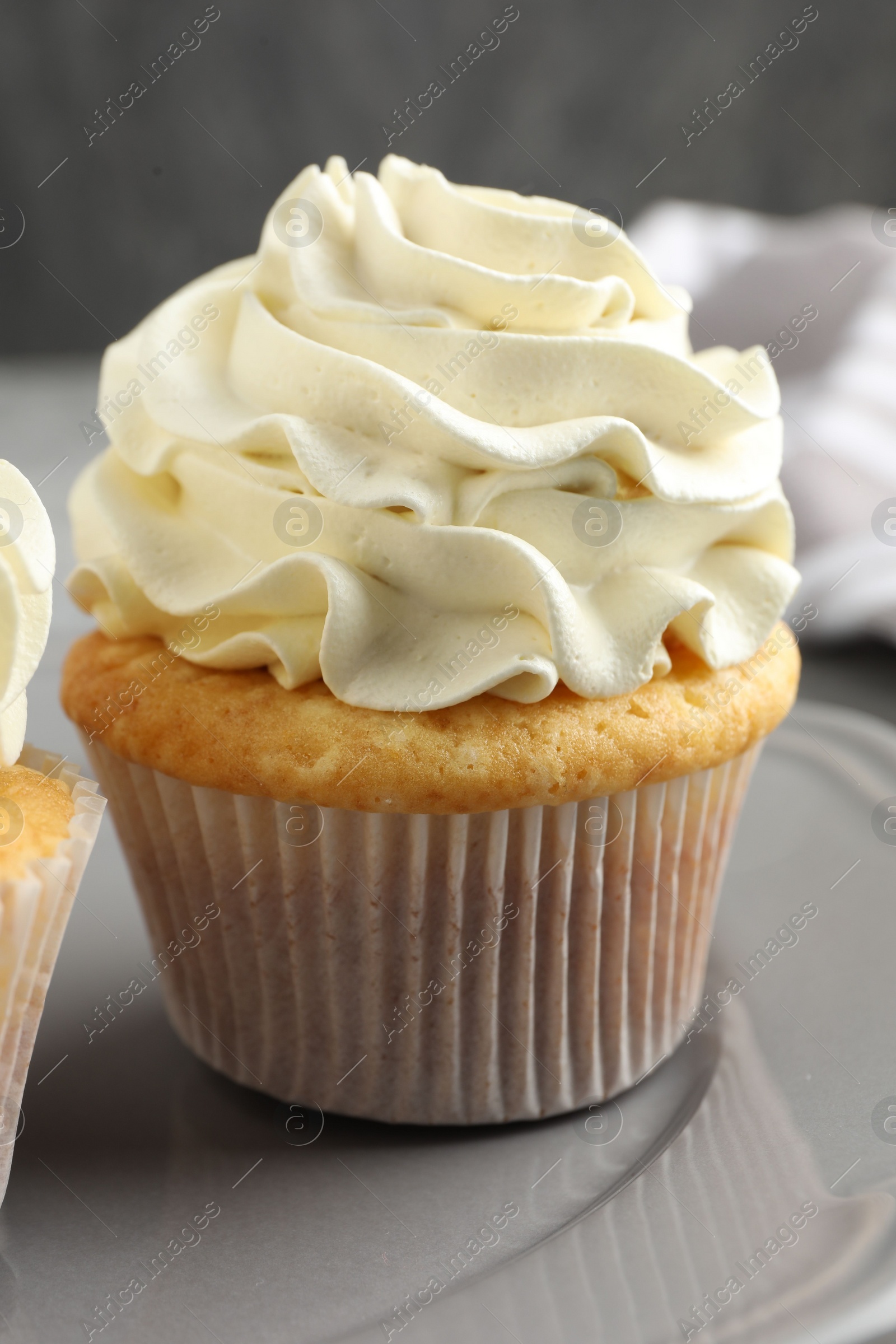 Photo of Tasty cupcakes with vanilla cream on table, closeup