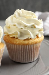 Tasty cupcakes with vanilla cream on table, closeup