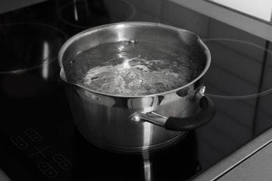 Pot with boiling water on electric stove in kitchen