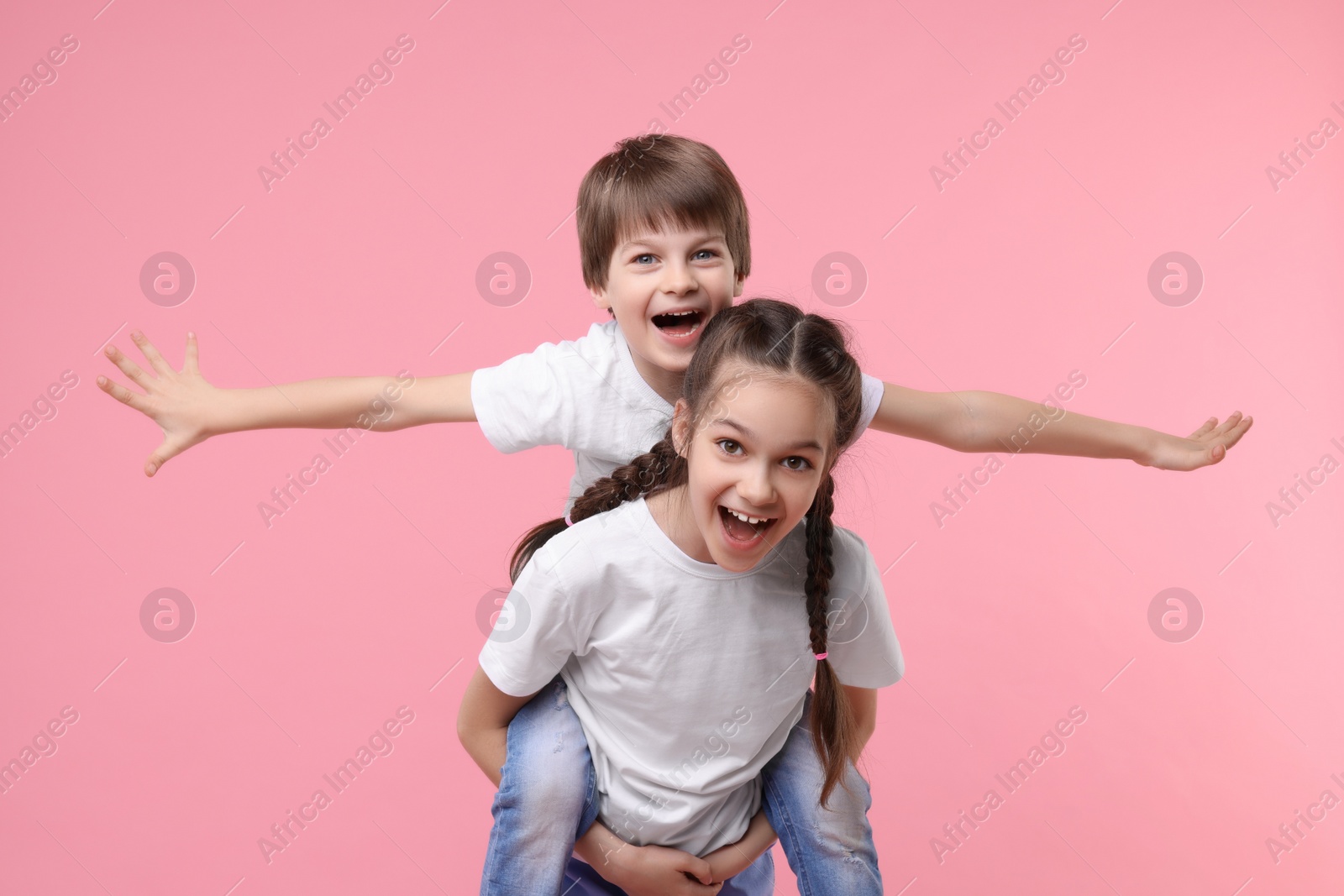 Photo of Happy brother and sister on pink background