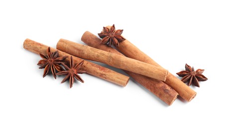 Photo of Aromatic cinnamon sticks and anise stars isolated on white, above view