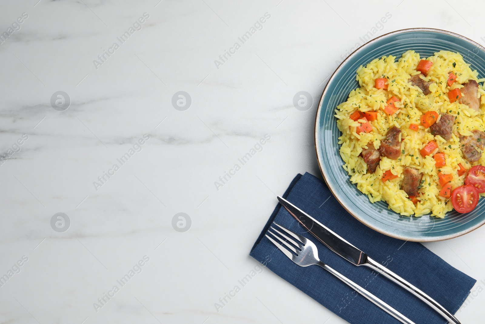 Photo of Delicious pilaf with meat served on white marble table, flat lay. Space for text