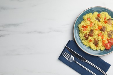 Delicious pilaf with meat served on white marble table, flat lay. Space for text