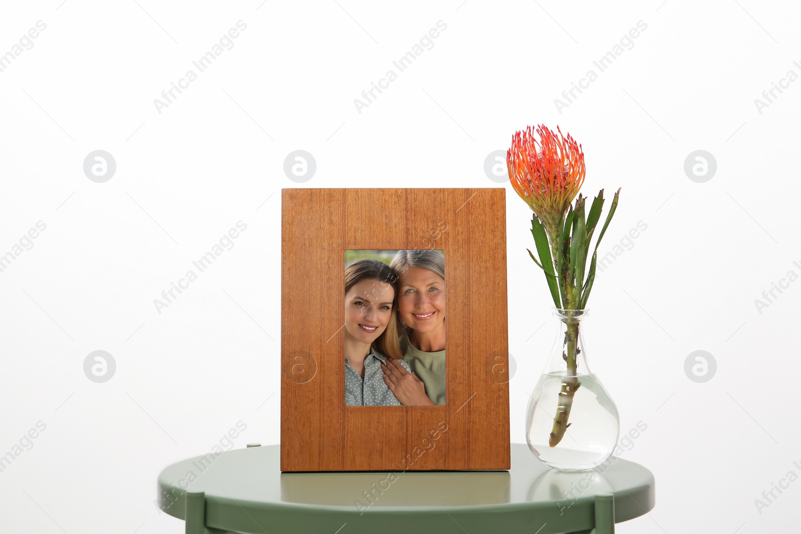 Image of Family portrait of mother and daughter in photo frame on table against white background