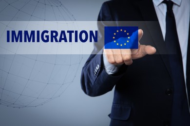 Image of Immigration. Businessman touching digital screen with word and flag of Europe on grey background, closeup