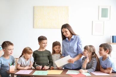 Cute little children with teacher in classroom at school