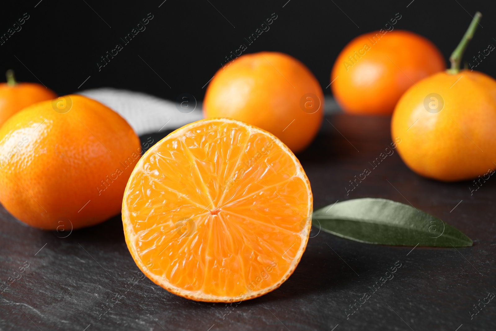 Photo of Fresh ripe juicy tangerines on slate board