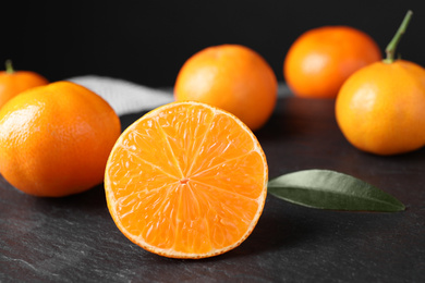 Photo of Fresh ripe juicy tangerines on slate board
