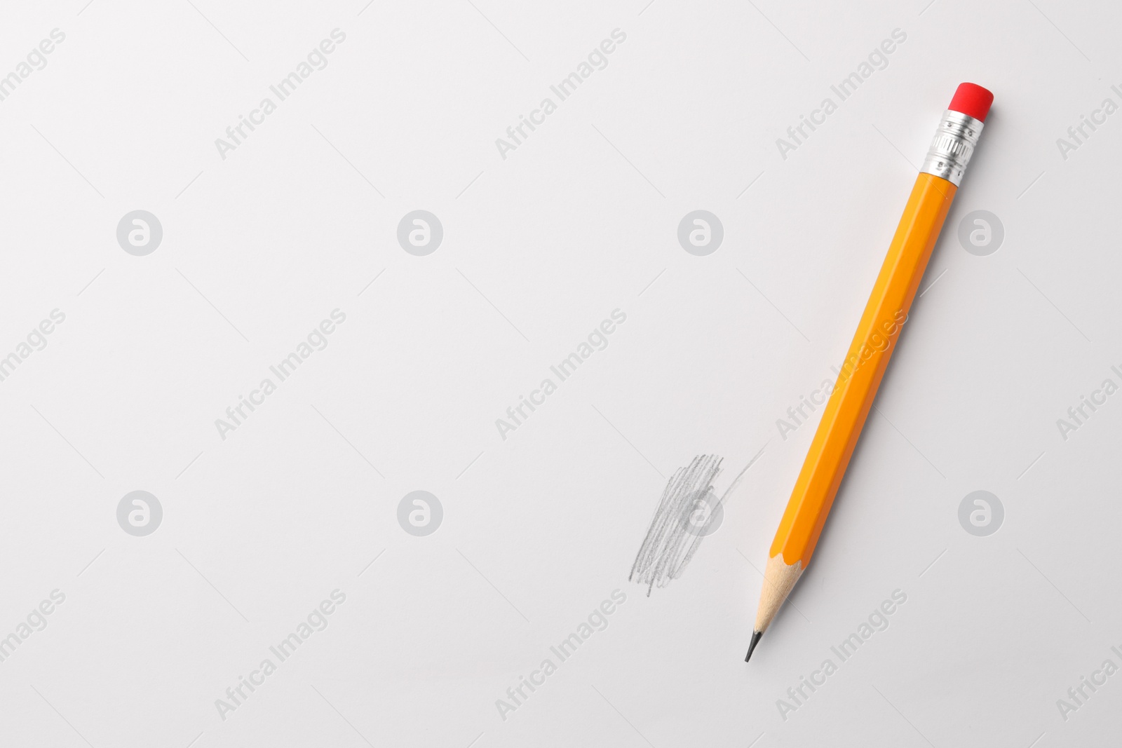 Photo of Sharp graphite pencil with eraser and hand drawn scribble on white sheet of paper, top view. Space for text