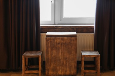 Photo of Wooden chairs and table near window in hotel room