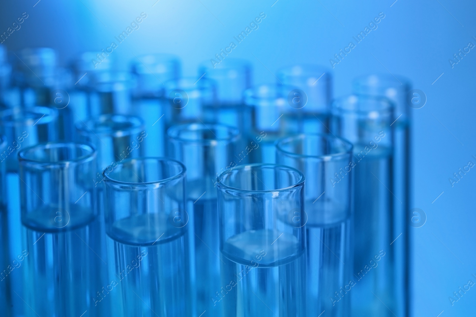 Photo of Test tubes with liquid against color background, closeup. Laboratory analysis