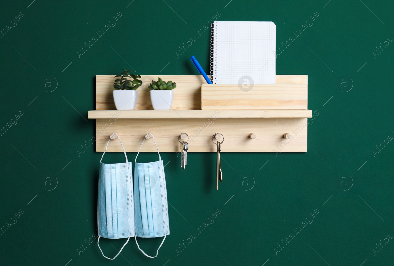 Photo of Wooden hanger for keys on green wall