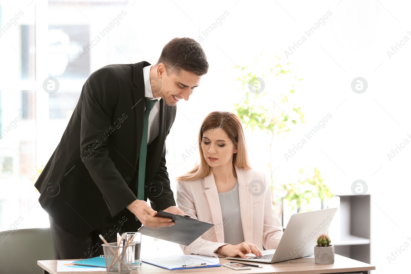 Photo of Young consultant working with client in office