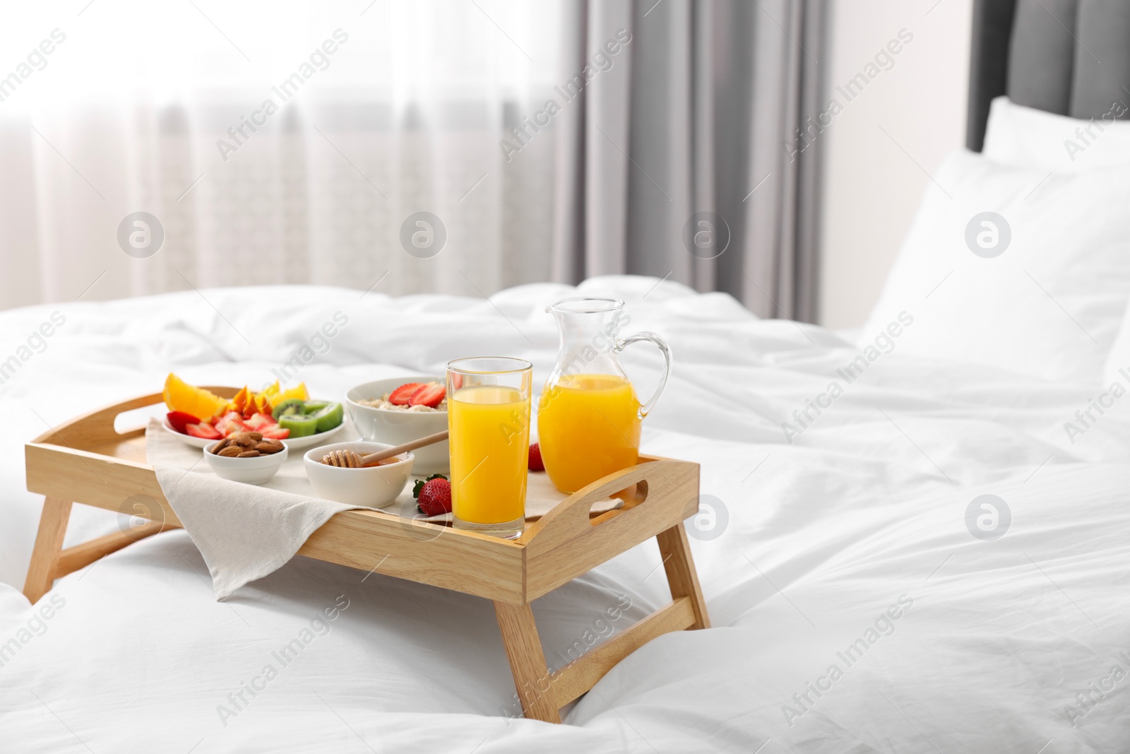 Tray with tasty breakfast on bed at home, space for text Photo of Tray with tasty breakfast on bed at home, space for text