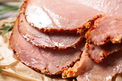 Photo of Slices of delicious cooked ham on parchment, closeup