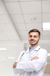 Portrait of male doctor in coat at workplace