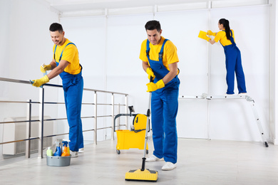 Team of professional janitors cleaning room after renovation