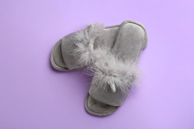 Pair of stylish soft slippers on violet background, flat lay