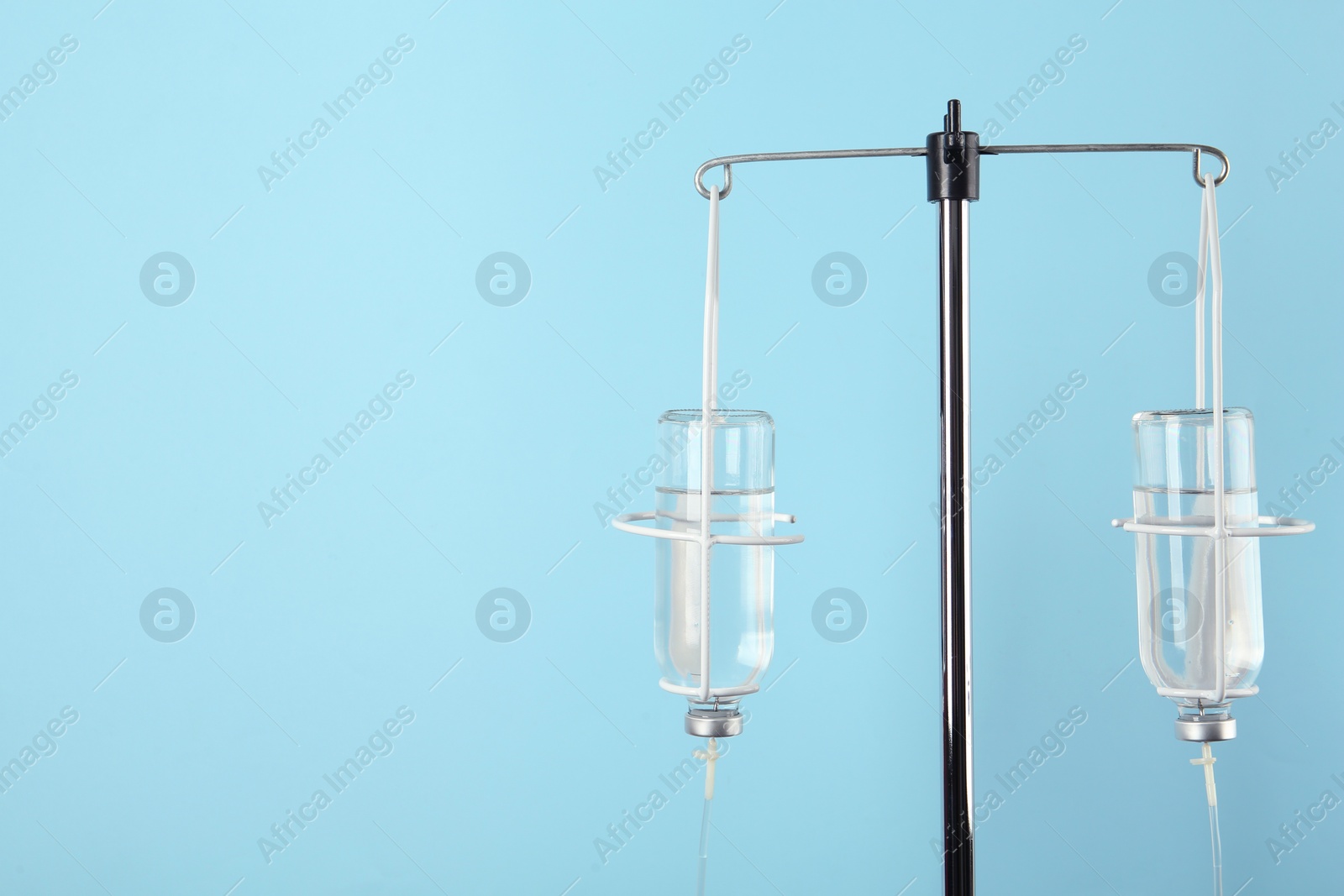 Photo of IV infusion set on light blue background. Space for text