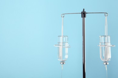 Photo of IV infusion set on light blue background. Space for text