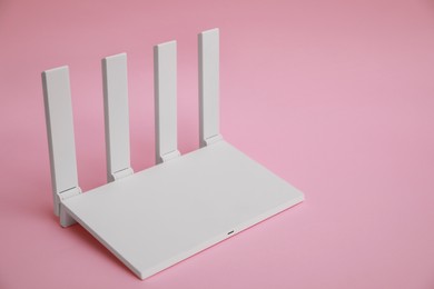 Modern Wi-Fi router on pink background. Space for text