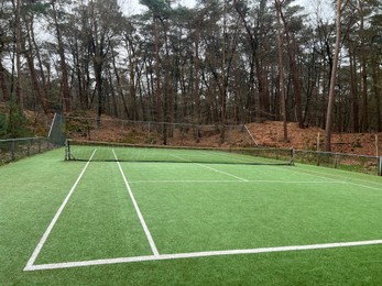 Tennis court with artificial grass and net outdoors