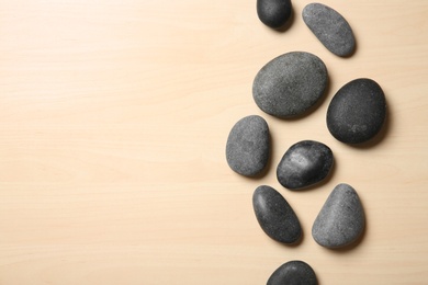 Spa stones on wooden background, top view. Space for text