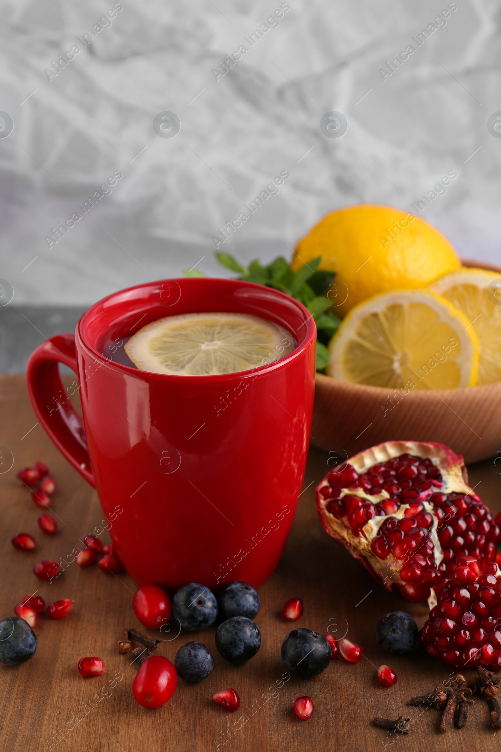 Photo of Cup with delicious immunity boosting tea and ingredients on table