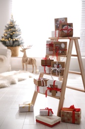 Photo of Advent calendar with gifts in room decorated for Christmas