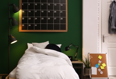 Modern teenager room interior with comfortable bed against green wall