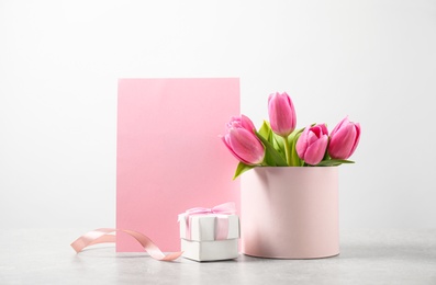 Photo of Composition with greeting card and tulips on light table, space for text. Happy Mother's Day