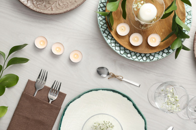 Photo of Elegant table setting with green plants on white wooden background, flat lay