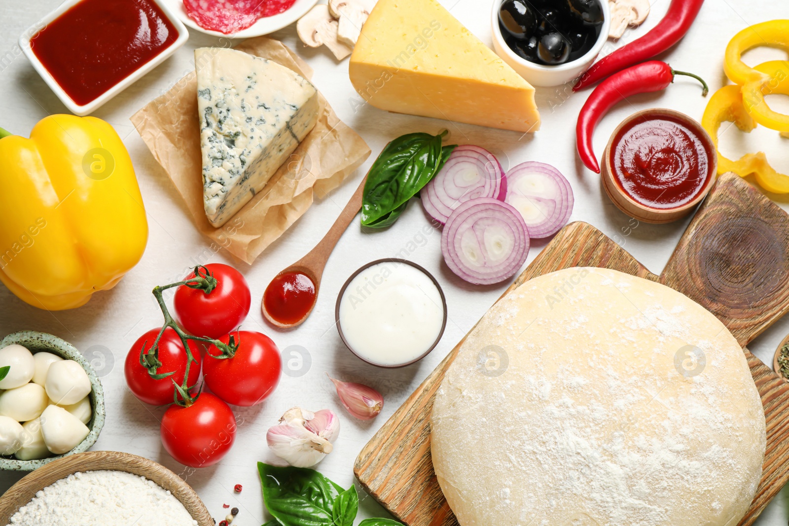 Photo of Flat lay composition with dough and fresh ingredients for pizza on white wooden table