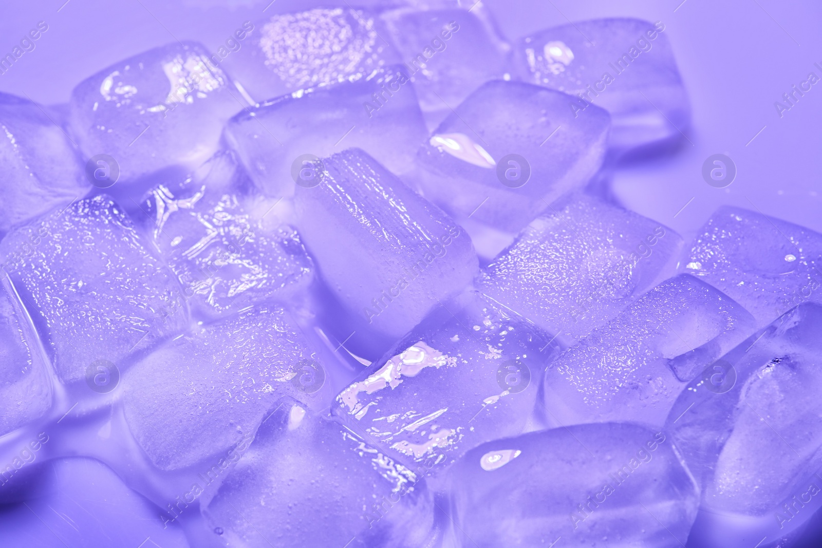 Photo of Melting ice cubes on color background. Frozen liquid