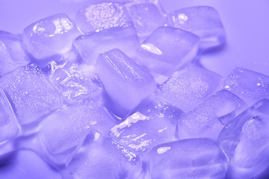 Melting ice cubes on color background. Frozen liquid