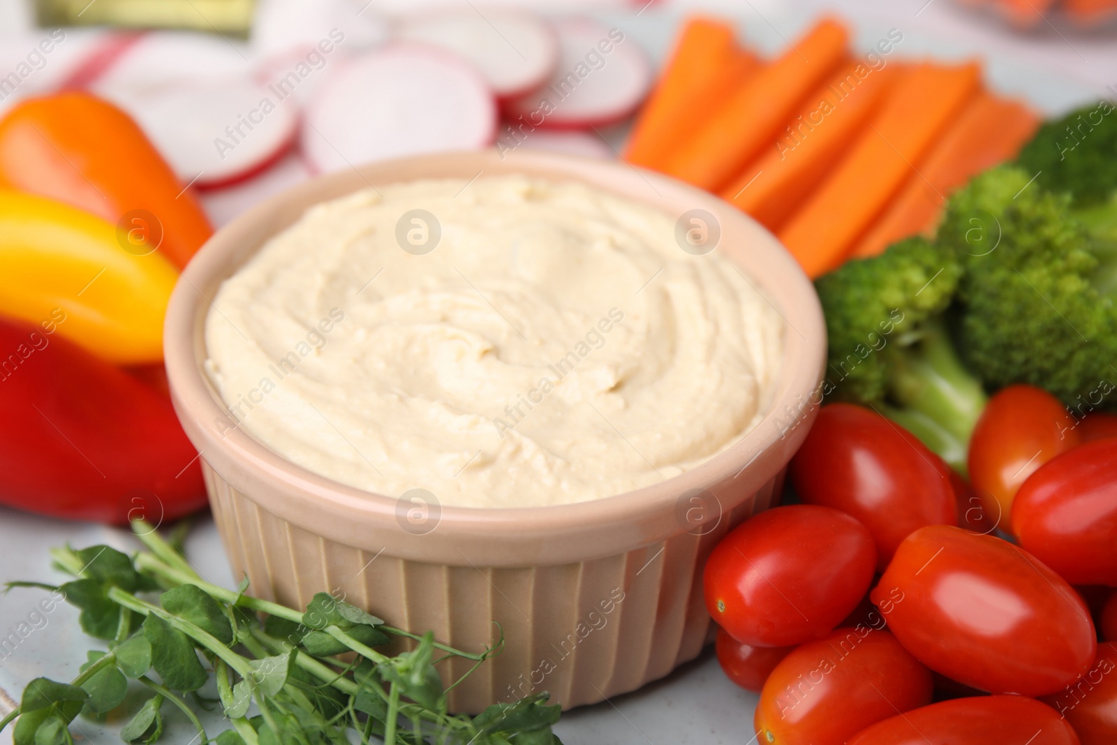 Photo of Plate with delicious hummus and fresh vegetables, closeup