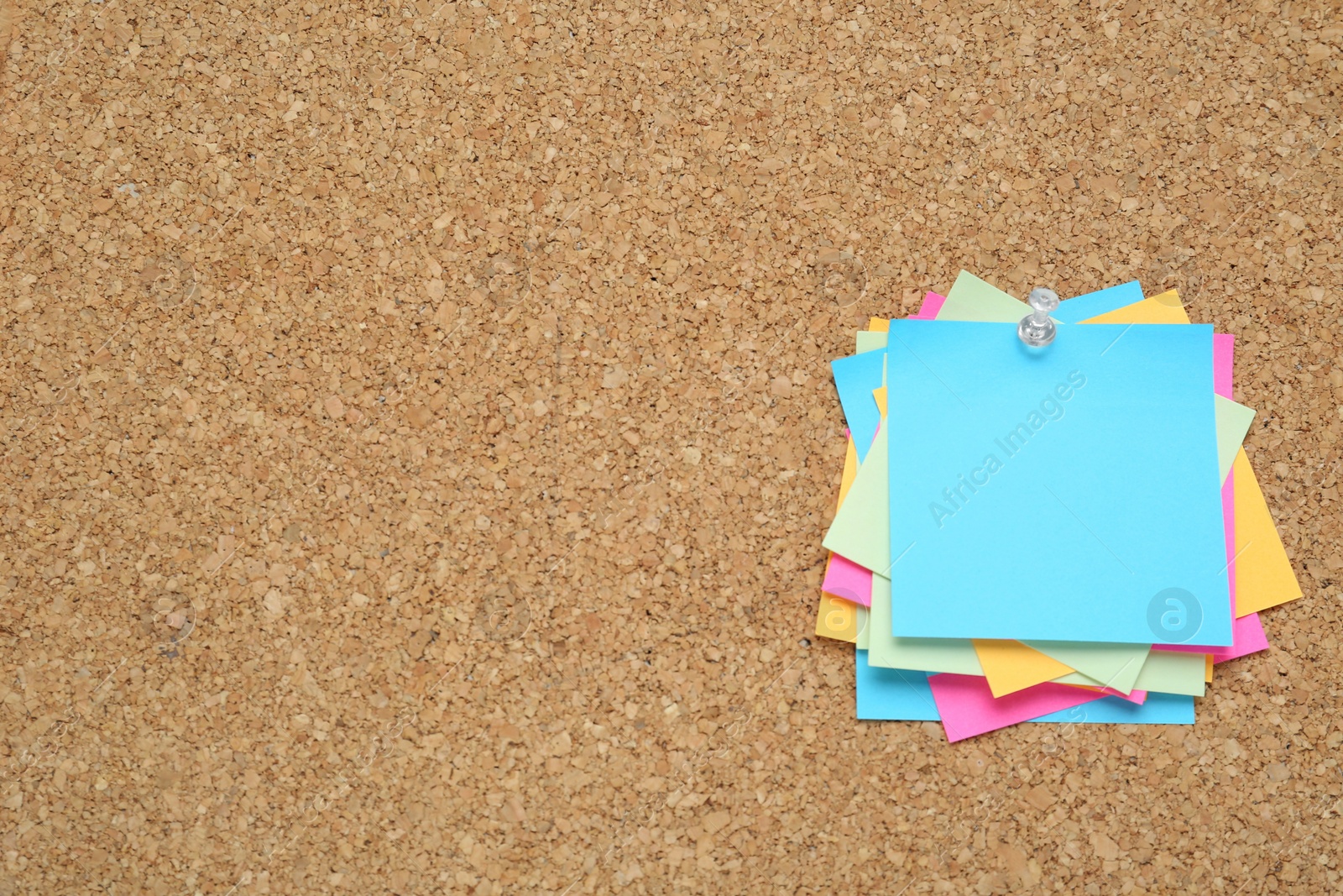 Photo of Many colorful notes pinned to corkboard. Space for text