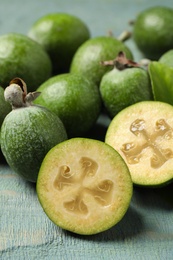 Photo of Fresh green feijoa fruits on blue wooden table, closeup