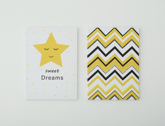 Photo of Adorable pictures of zigzag pattern and star with words SWEET DREAMS on white wall. Children's room interior elements