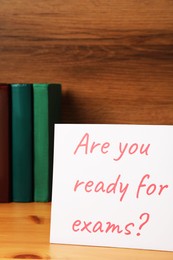 Photo of Card with question Are You Ready For Exams? on wooden table