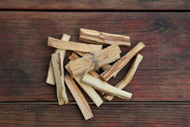 Photo of Many palo santo sticks on wooden table, flat lay