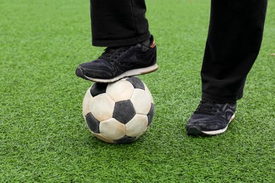 Photo of Man with soccer ball on green grass at stadium, closeup