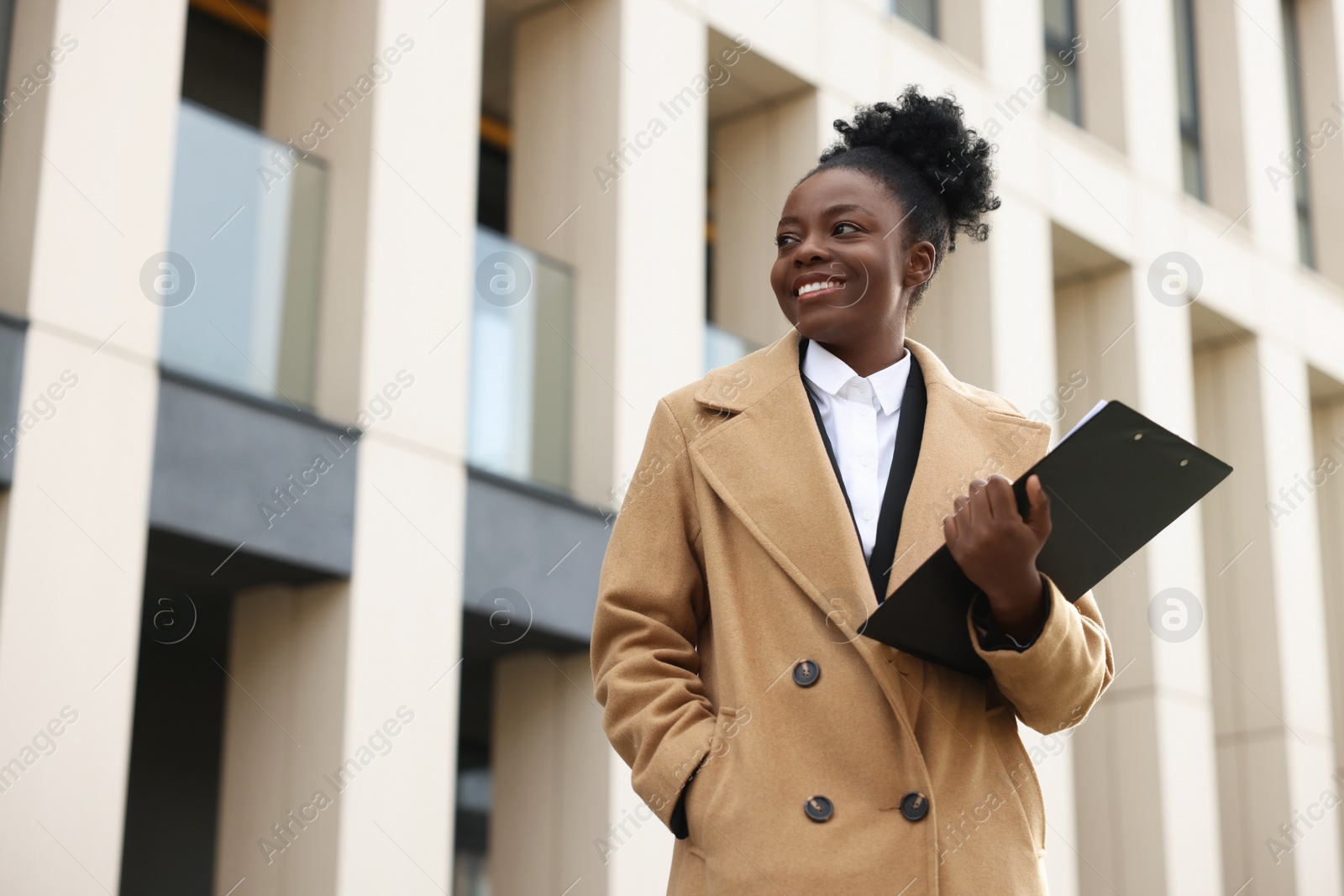 Photo of Happy woman with clipboard outdoors, space for text. Lawyer, businesswoman, accountant or manager