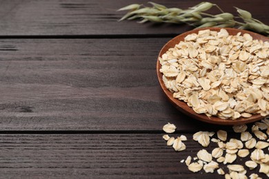 Oatmeal and florets on dark wooden table, closeup. Space for text