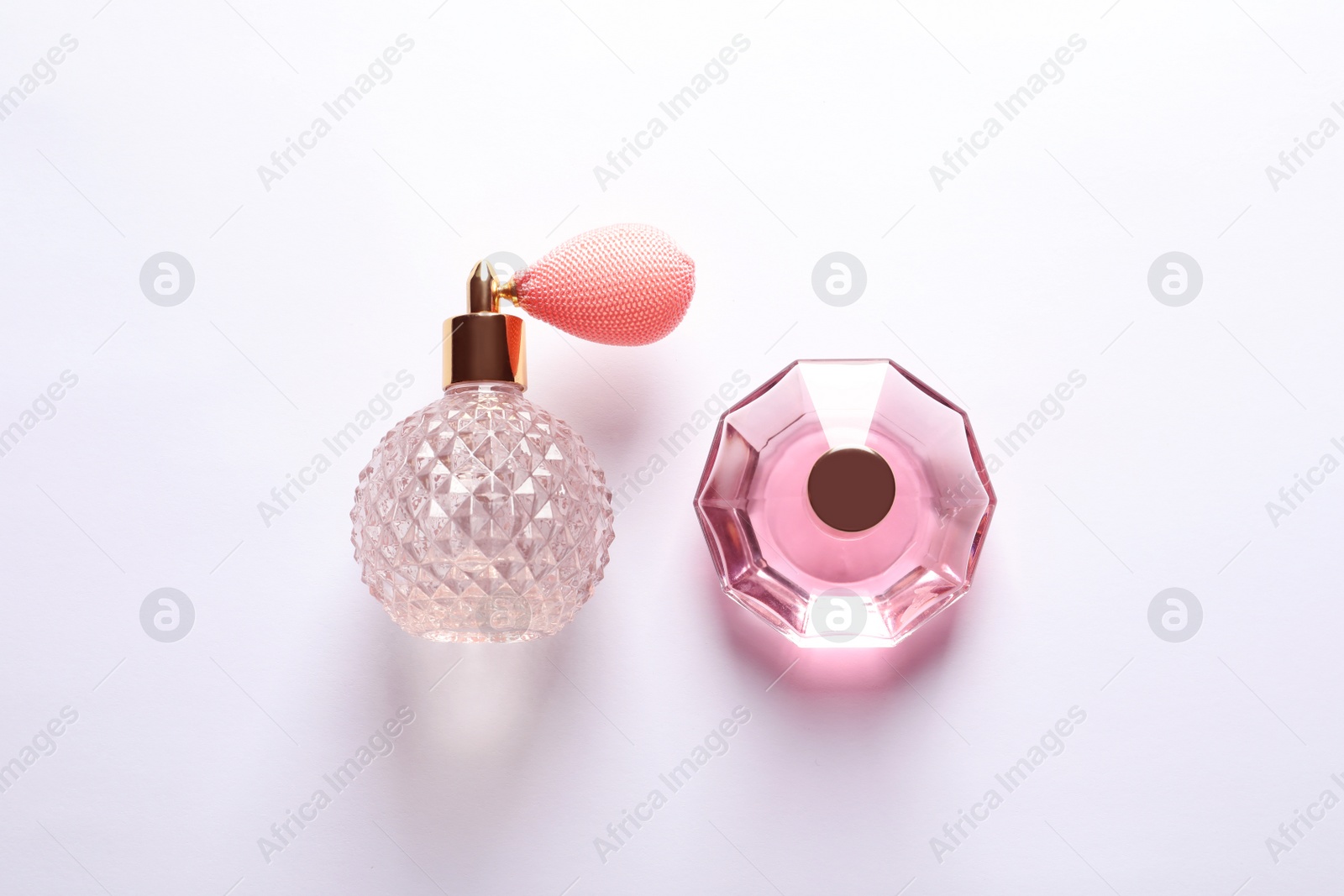 Photo of Composition with bottles of perfume on white background, top view