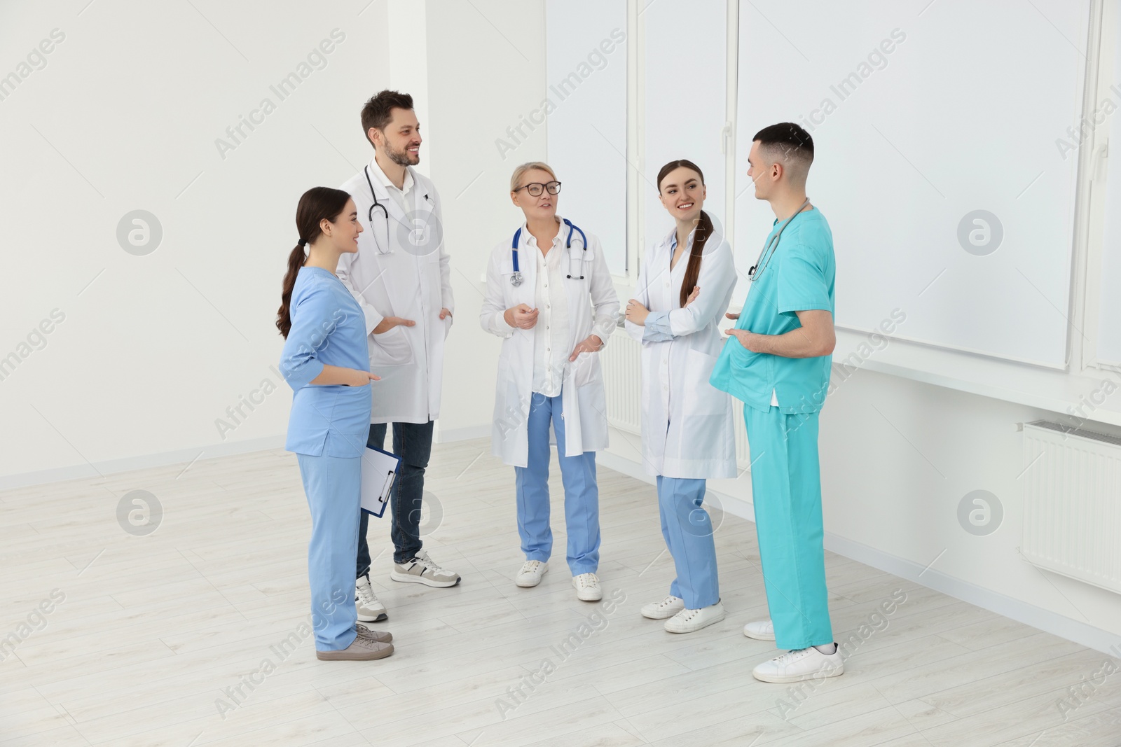 Photo of Medical doctors in uniforms having discussion in clinic