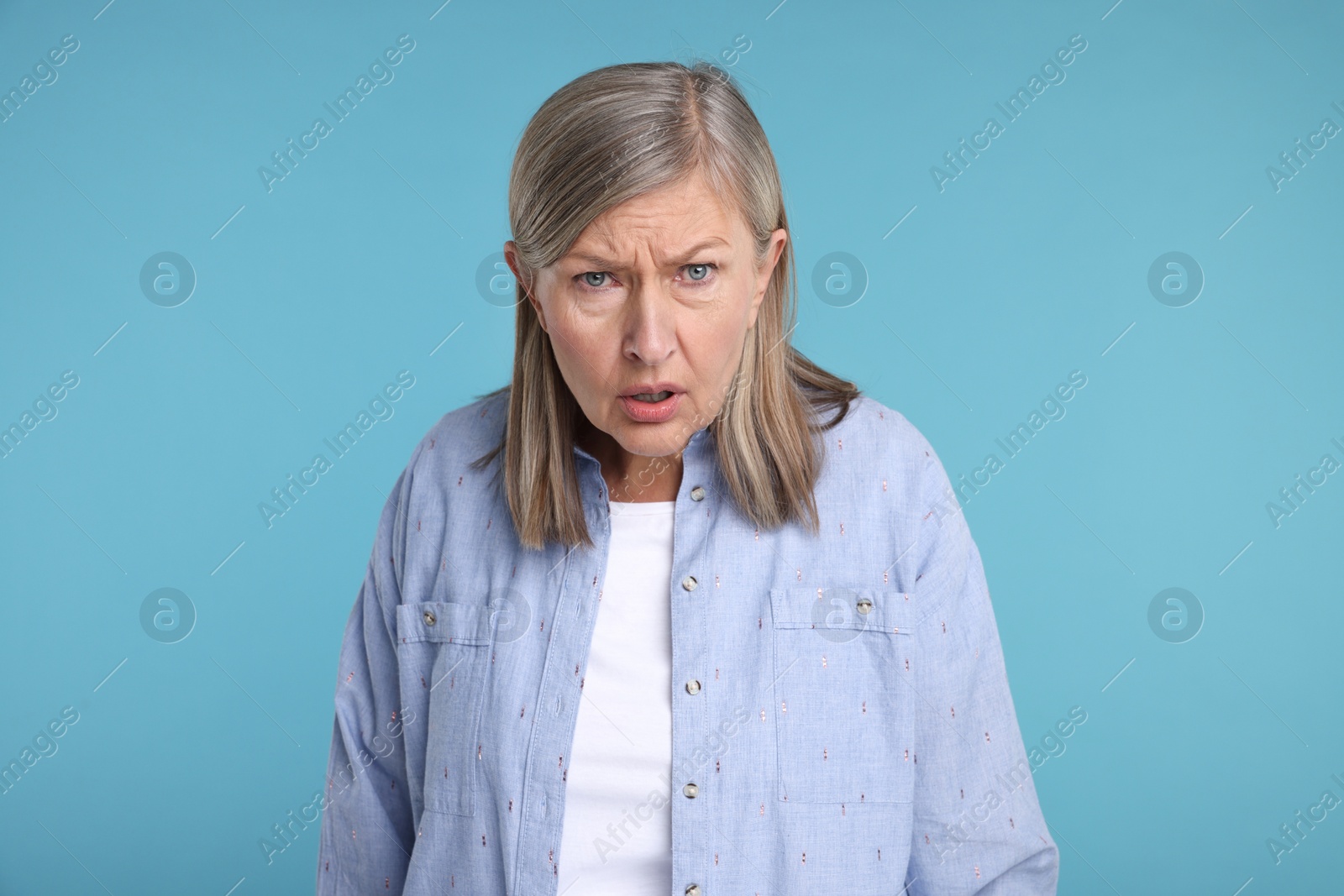Photo of Portrait of surprised senior woman on light blue background